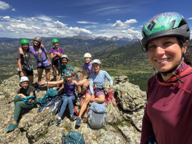 A group of climbers engaged in a thrilling outdoor activity, scaling a rugged rock face together while climbing in Estes Park.